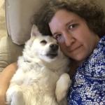 Miriam and her dog, Sasha, lying on the couch together.