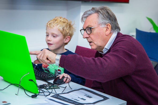 Older adult and child working together at Raspberry Jam